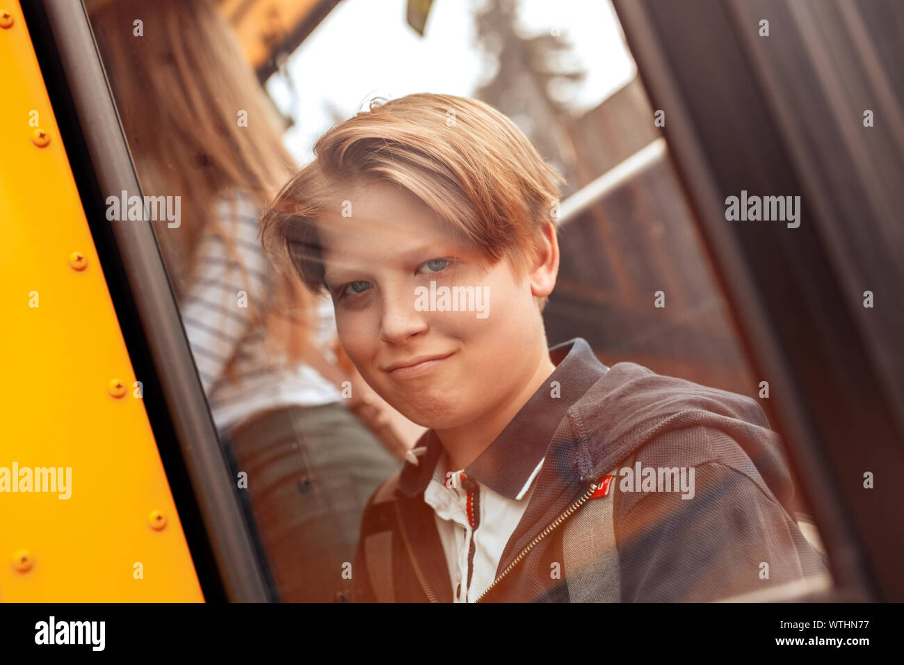 Mitschüler, mit dem Bus zur Schule Junge hinter Fenster schließen freudige Grimasse Stockfoto