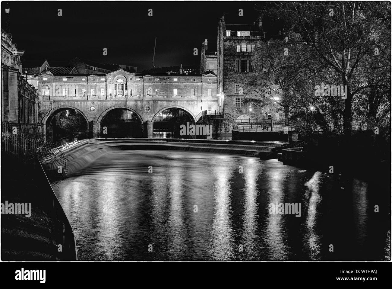 Schwarze und weiße Schuß von Pulteney Bridge und Wehr in Bath, England, bei Nacht Stockfoto