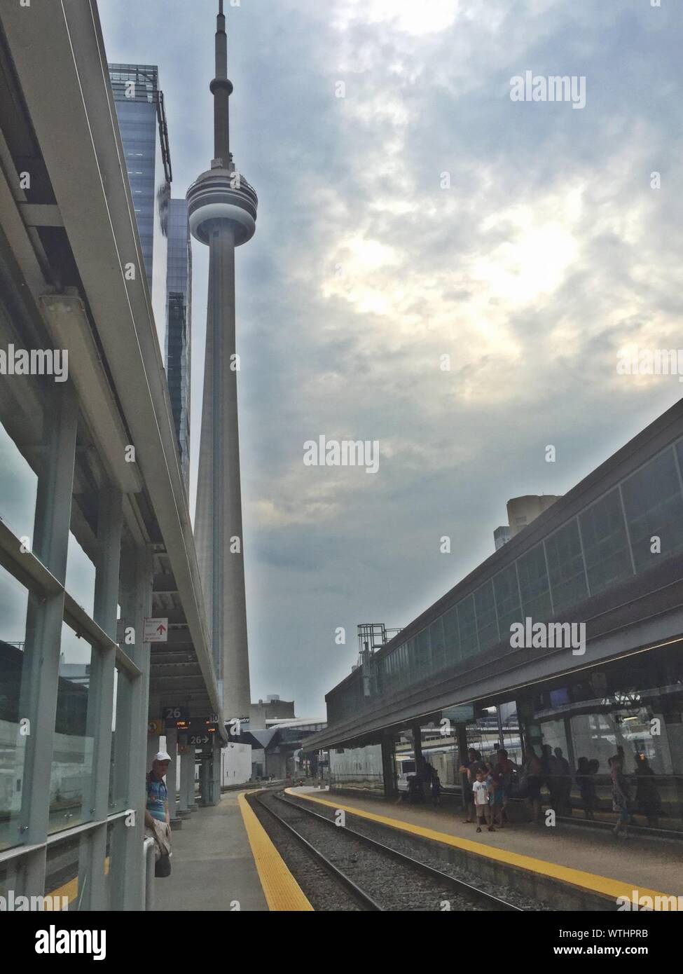 Bahnhof von CN Tower gegen bewölkter Himmel Stockfoto