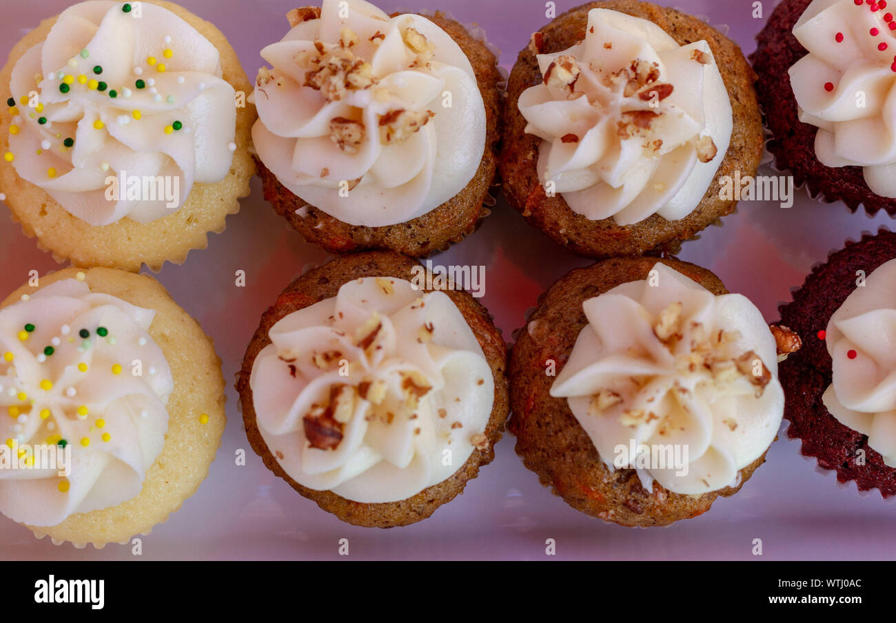Cupcakes auf einem Lavendel Keramik Fach von oben gesehen. Mehrfarbige Cupcakes mit rotem Samt, Vanille, Schokolade, Zitrone und Erdbeere Aromen. Stockfoto