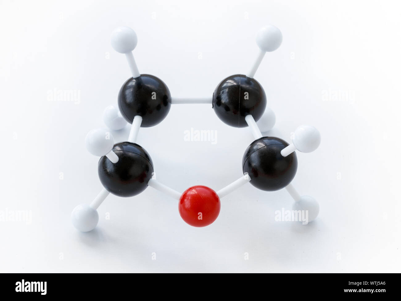 Kunststoff Kugel-und-stick Modell eines Tetrahydrofuran (THF) Molekül (Formel: (CH2)4 O oder C4H8O) auf einem weißen Hintergrund. Tetrahydrofuran ist ein Beispiel für eine Stockfoto