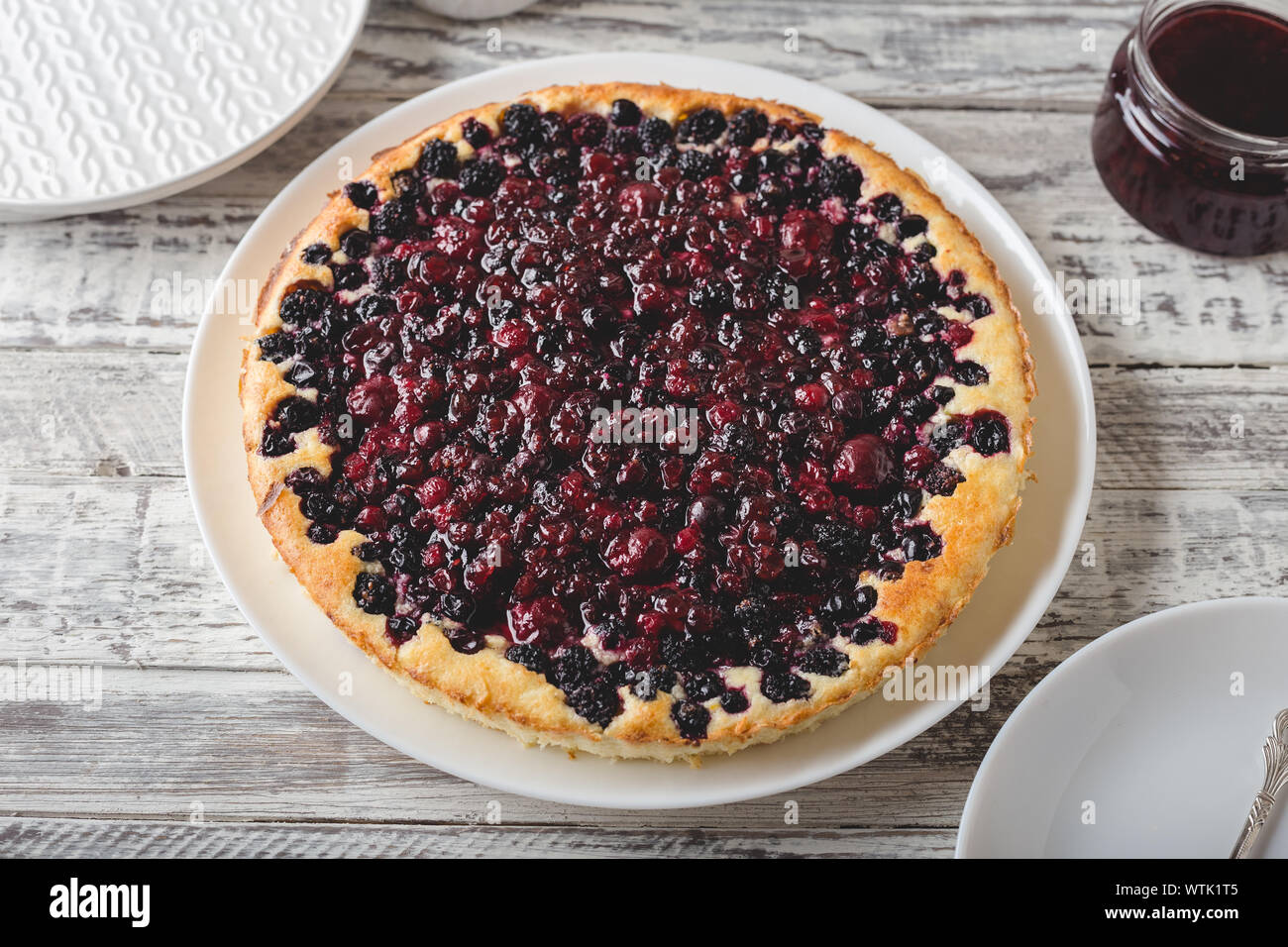 Berry pie mit Kirsche, Johannisbeere, Brombeere, Heidelbeere auf weissem Holztisch. Käsekuchen. Stockfoto