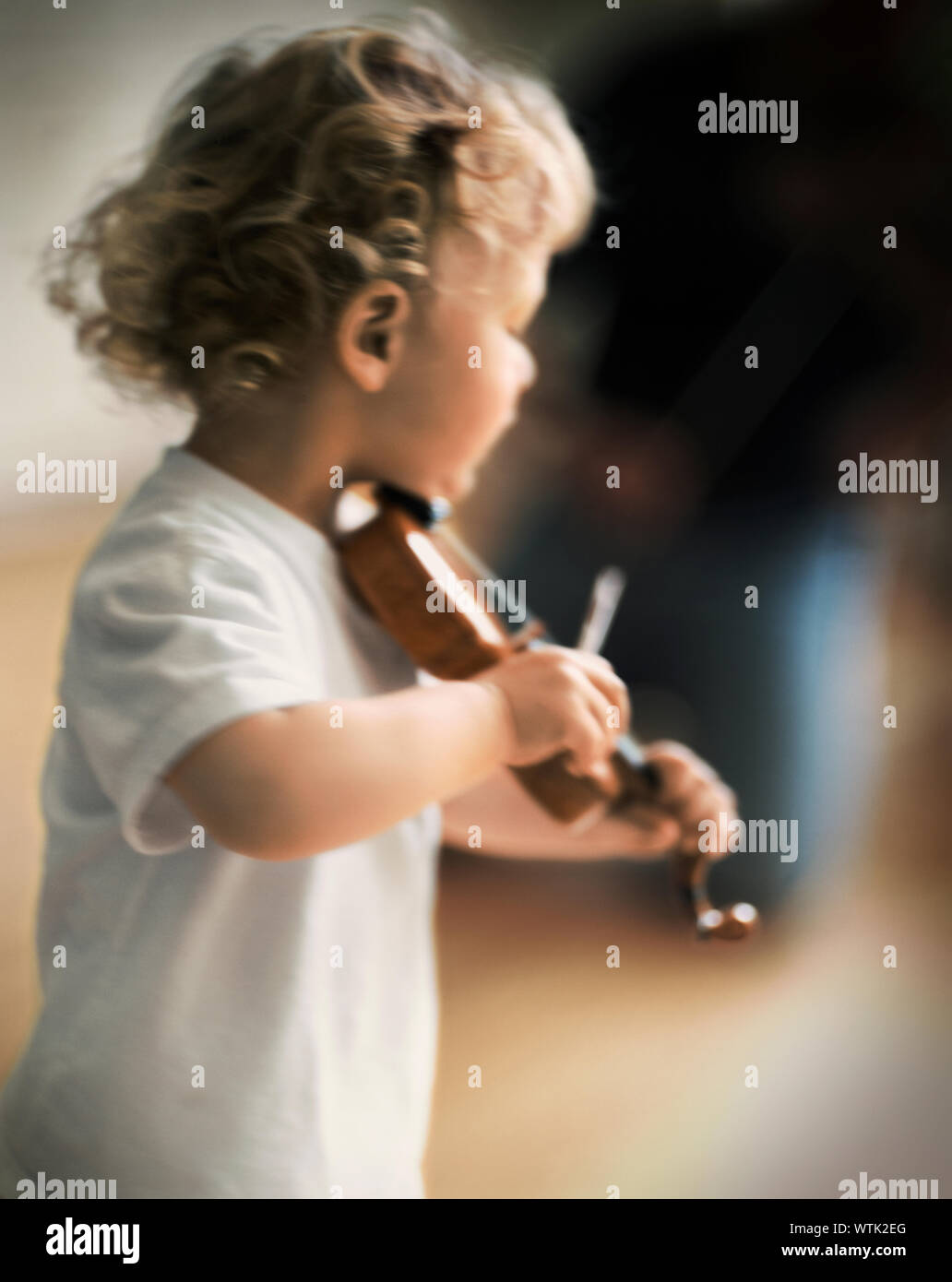 Kleinkind Junge spielt eine Miniatur Violine Stockfoto