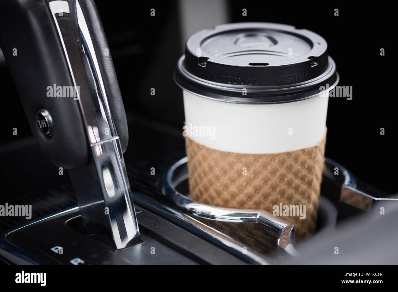 Kaffee in Einweg- Cup im Auto. Stockfoto