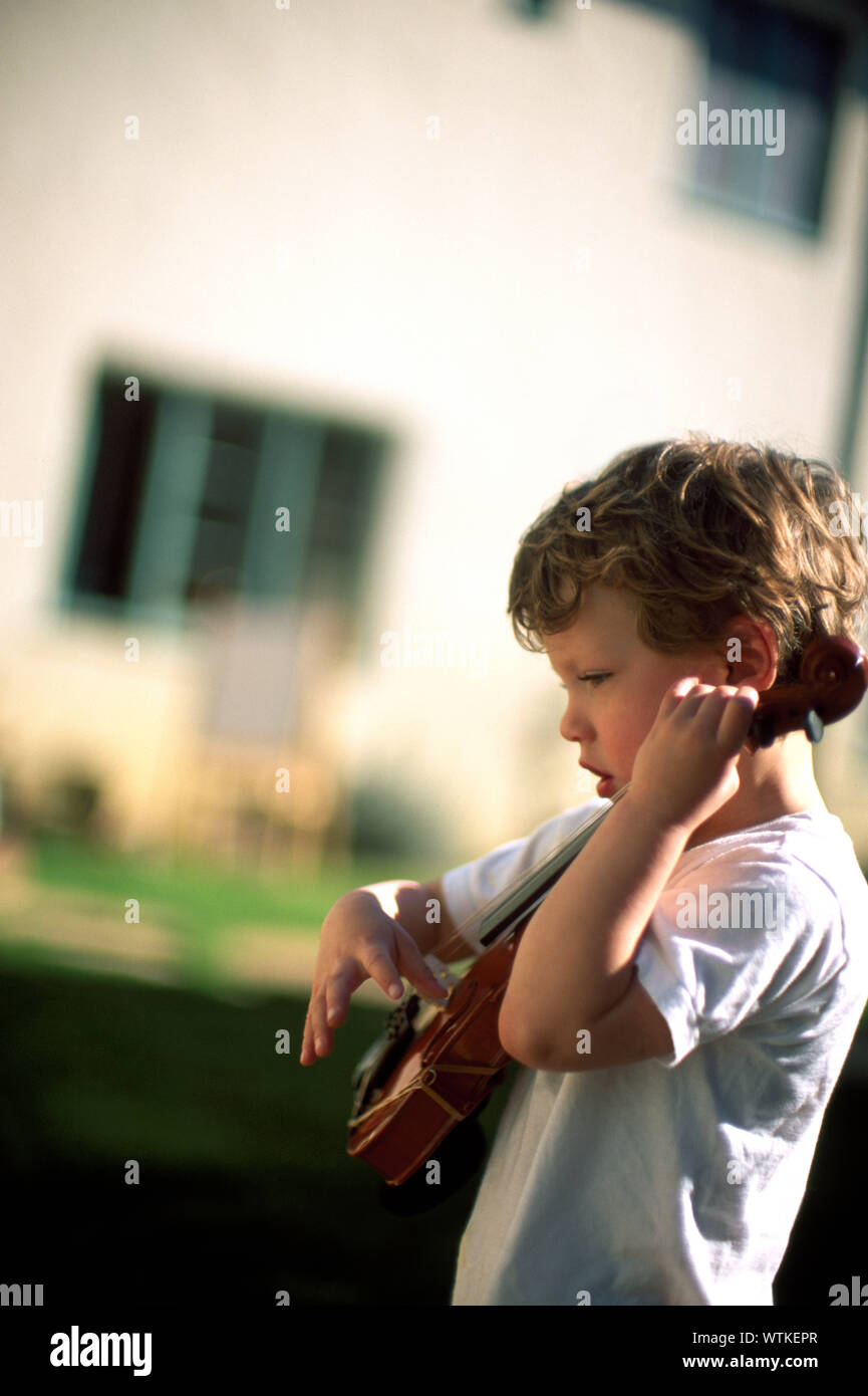 Wenig Junge spielt mit einer Geige Stockfoto