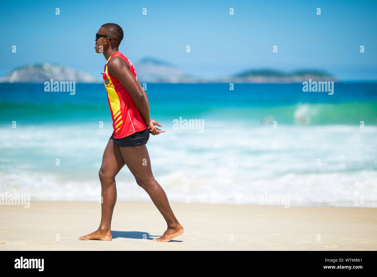 RIO DE JANEIRO - 15. MÄRZ 2018: Eine brasilianische Rettungsschwimmer Spaziergänge entlang der Ufer des Ipanema Beach, der hat einen guten Ruf für große Wellen und Rip-Ströme. Stockfoto