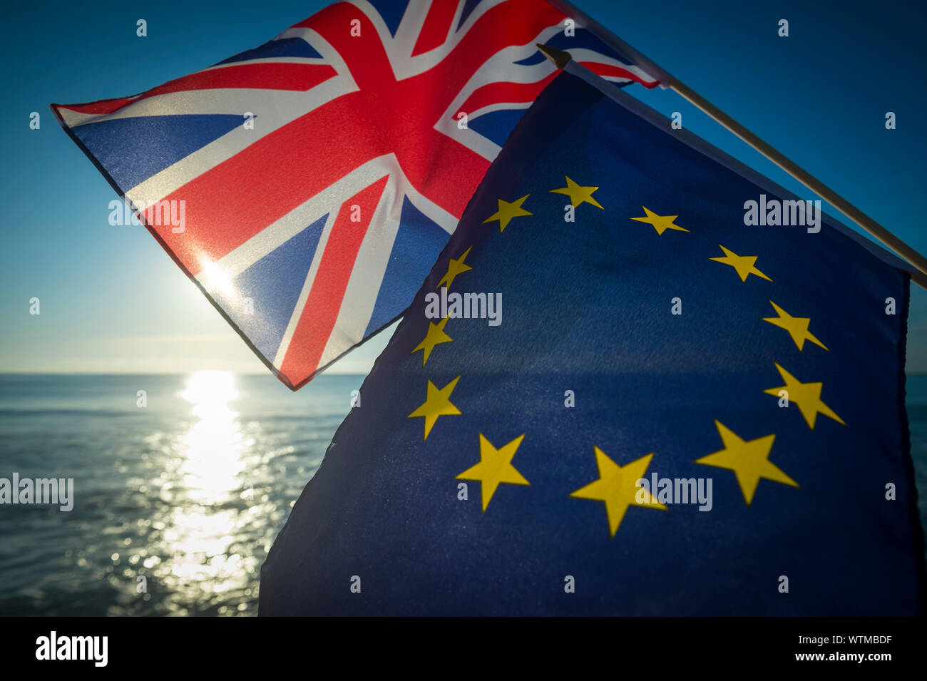 Europäischen Union und der britische Union Jack Fahnen fliegen zusammen wie die Sonne geht in eine neue Ära auf das Verhältnis zwischen der EU und Großbritannien nach Brexit Stockfoto