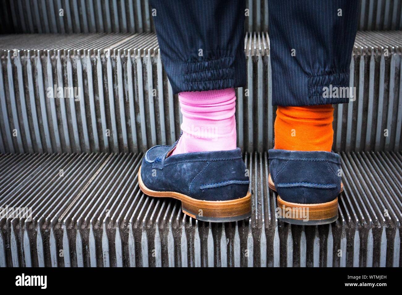 Mittelteil einer Person tragen zwei verschiedene Socken an Escalator  Stockfotografie - Alamy