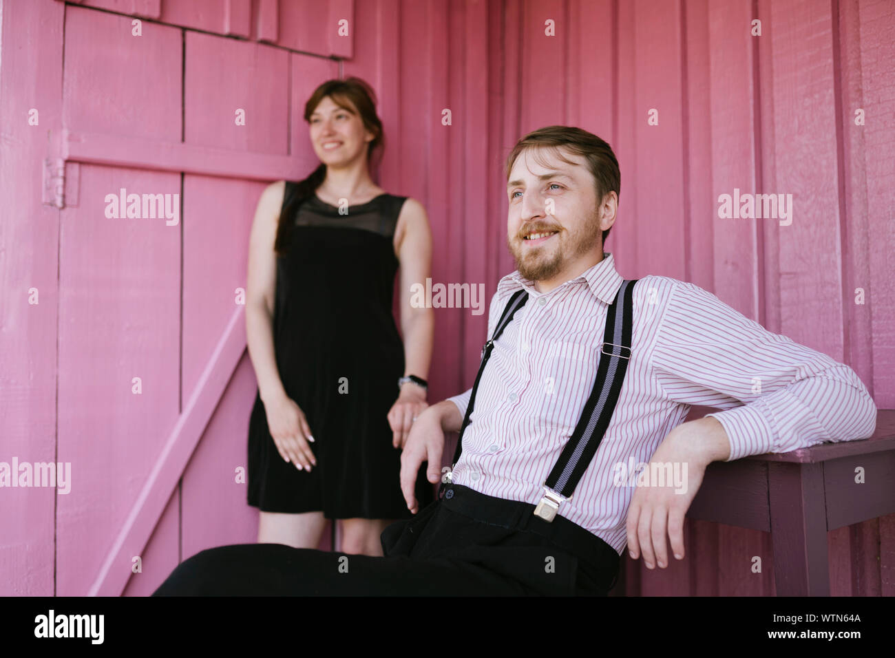 Happy ländlichen Paar auf rosa Wand Hintergrund Stockfoto