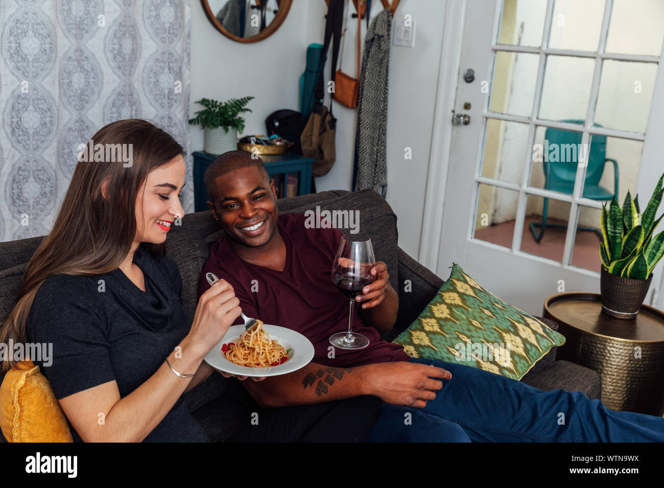 Ein paar hängt heraus zusammen im Wohnzimmer, während Dinner essen. Stockfoto