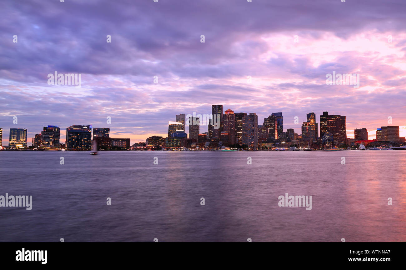 Boston Skyline bei Sonnenuntergang, mit violetten Himmel und Ozean, Massachusetts, USA Stockfoto