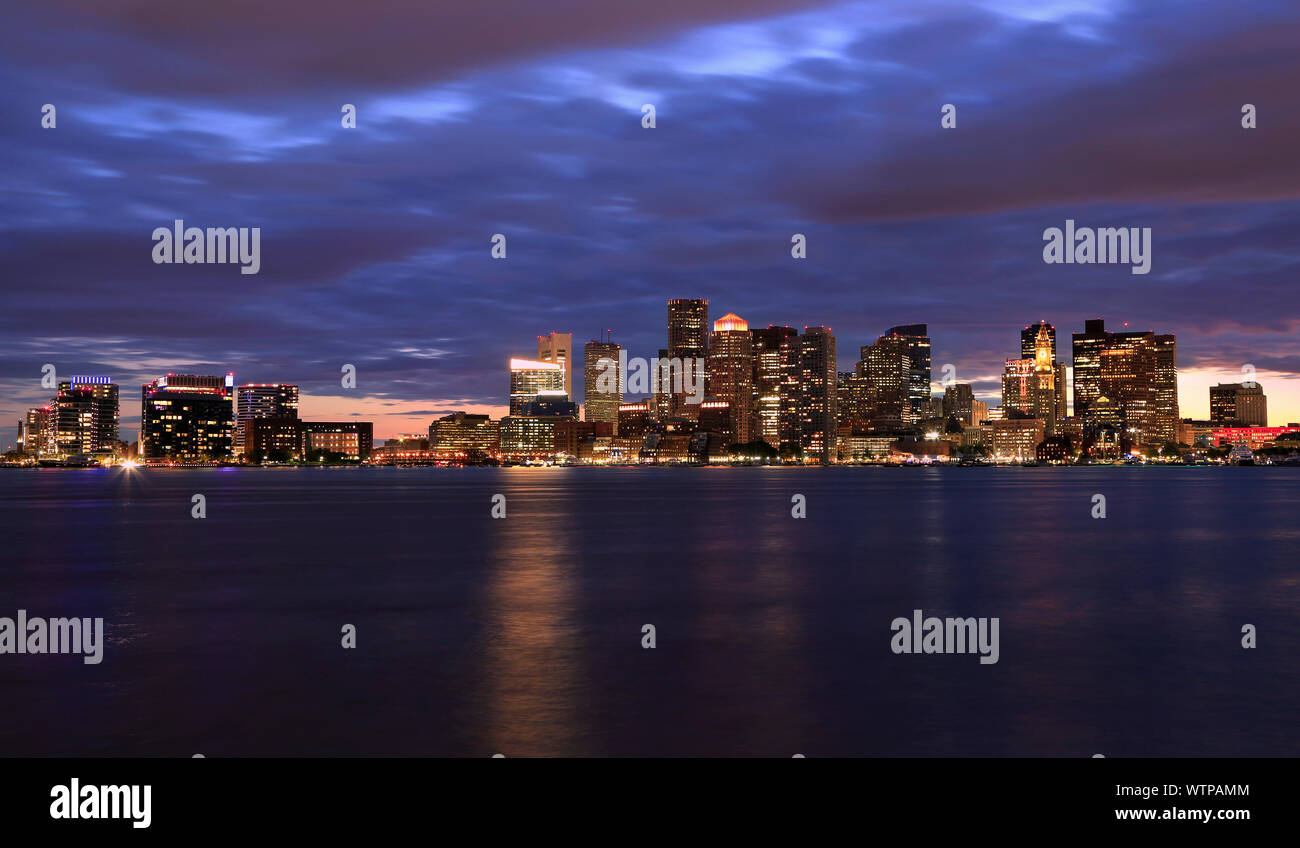 Boston Skyline bei Nacht, mit Wolkenkratzern Reflexion über den Ozean, Massachusetts, USA Stockfoto