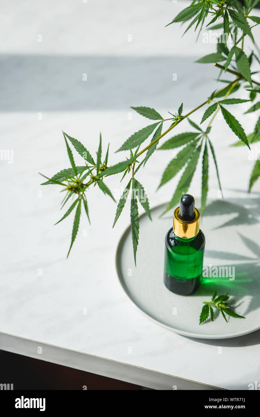 Glasflasche mit Cannabis Öl mit Hanf Blätter auf einem Marmor Hintergrund. Kopieren Sie Platz. Stockfoto