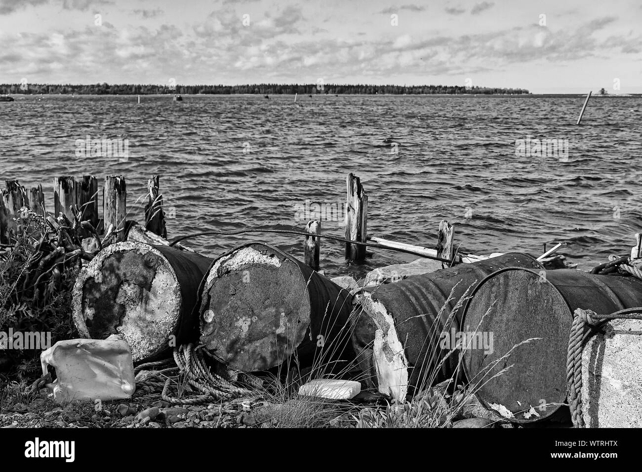 Alte Fässer haben zu faulen wurde durch die Überreste einer alten hölzernen Pier am Fischerhafen von Kalajoki, Finnland links. Stockfoto