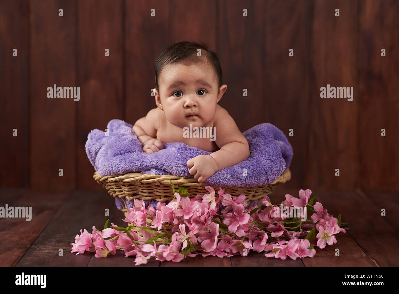 Cute Baby schauen in die Kamera auf dunklen Studio Holz- Hintergrund Stockfoto