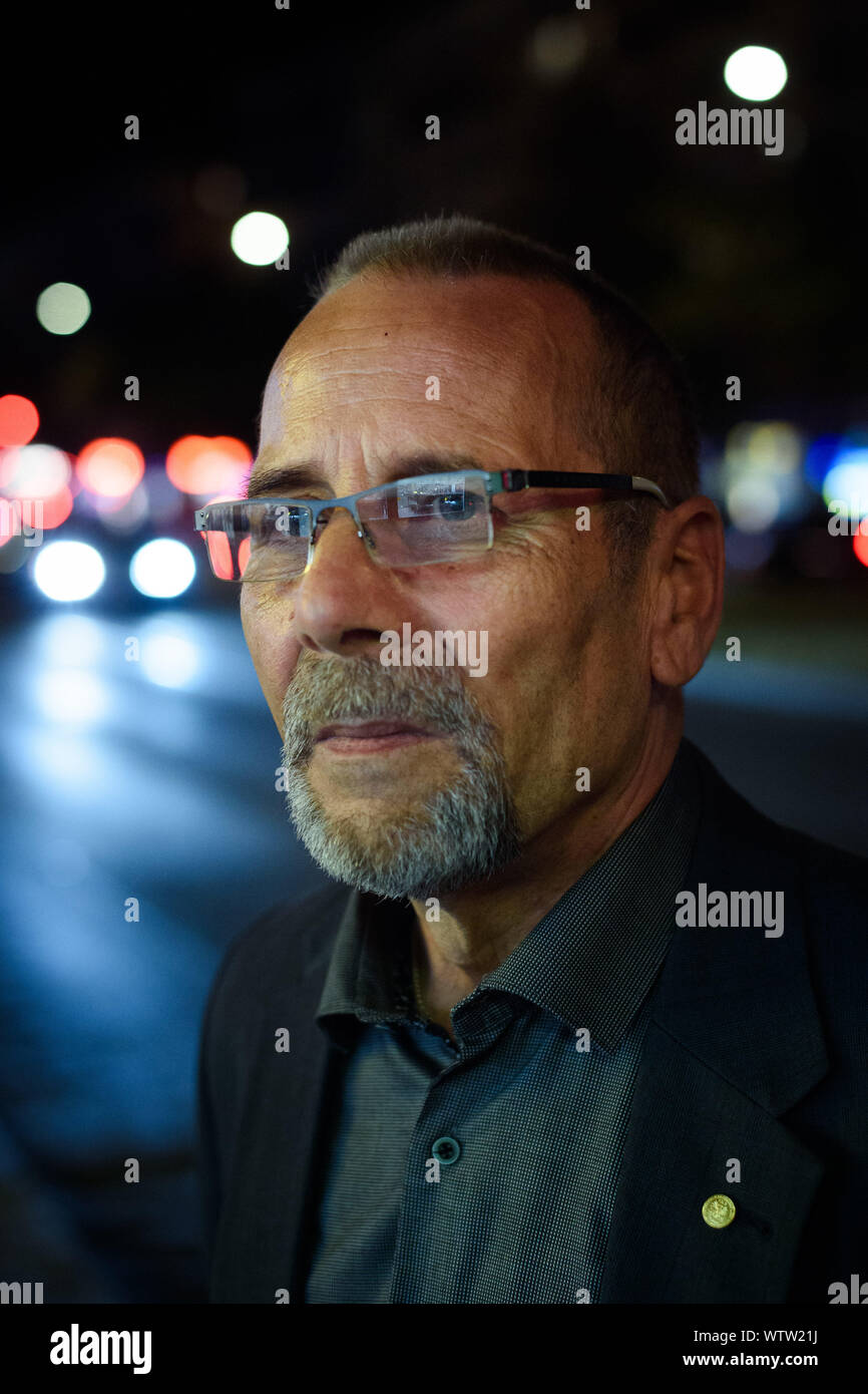 Berlin, Deutschland. 04 Sep, 2019. Peter-Christian Bürger, Zeitzeuge und Mitglied der Bundesstiftung Aufarbeitung der SED-Diktatur, Spaziergänge durch eine Straße im Berliner Bezirk Friedrichshain nach einem Arbeitstag im Licht einer Straßenlaterne. Sein Gesicht leuchtet durch eine Leuchtreklame. (Dpa-Geschichte: 30 Jahre Prager Botschaft) Credit: Gregor Fischer/dpa/Alamy leben Nachrichten Stockfoto