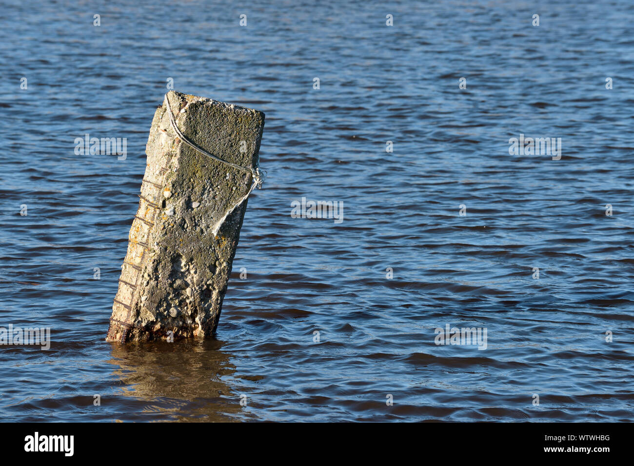 Alte Beton Säule in den See gehämmert Stockfoto