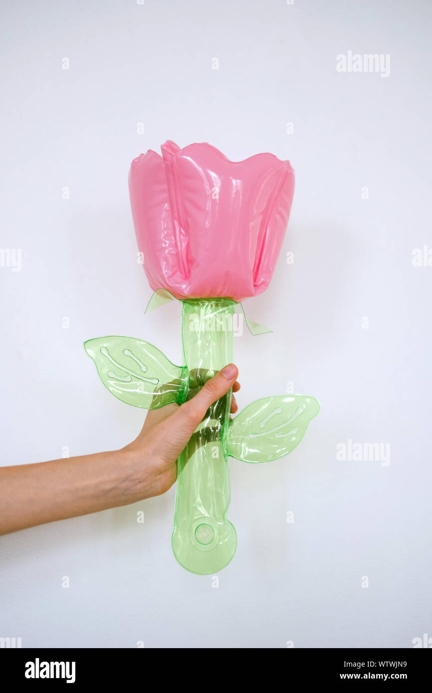 Junge Frau hält eine aufblasbare Blume Spielzeug Stockfoto
