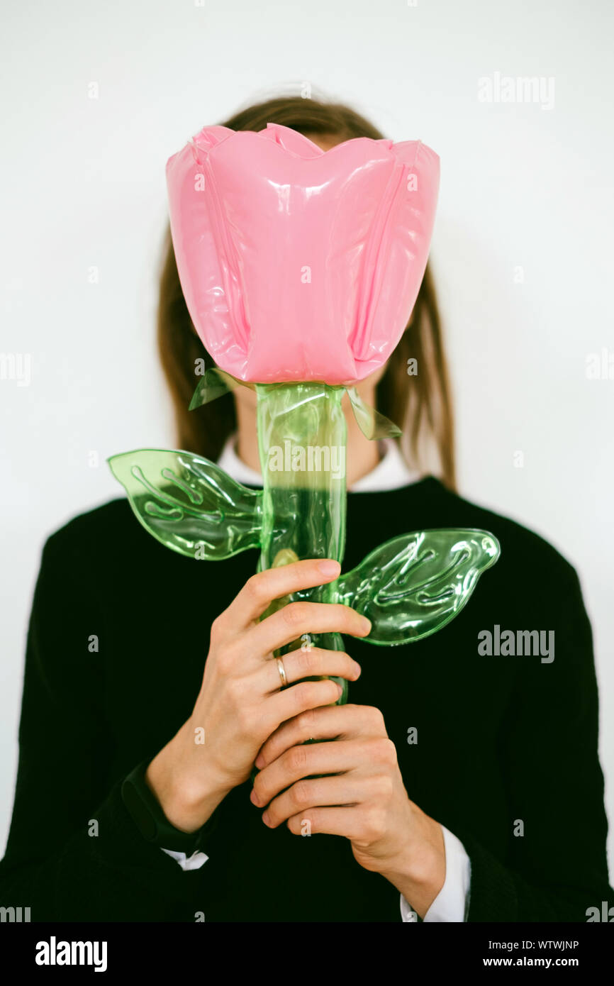 Junge Frau hält eine aufblasbare Blume Spielzeug Stockfoto