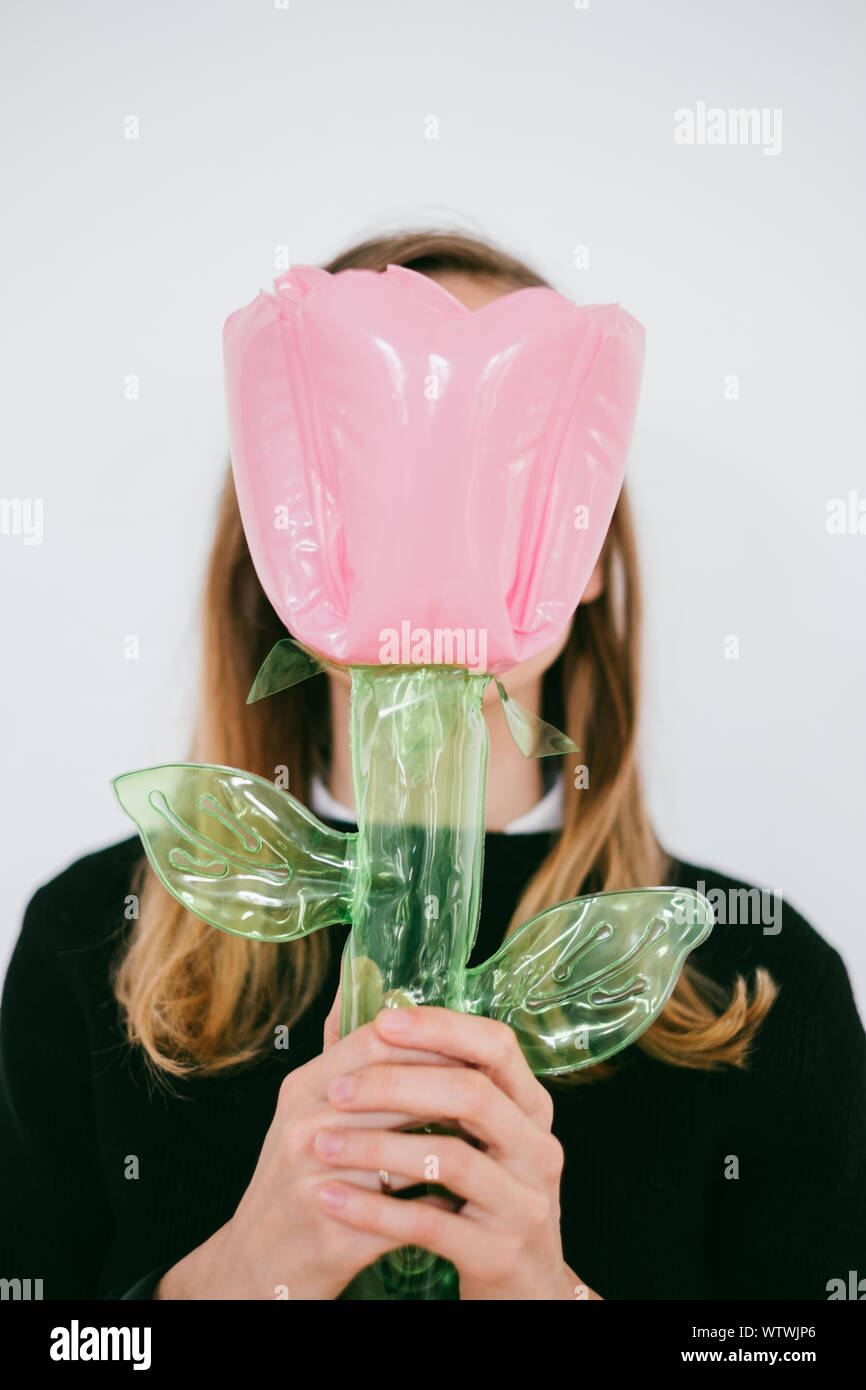 Junge Frau hält eine aufblasbare Blume Spielzeug Stockfoto