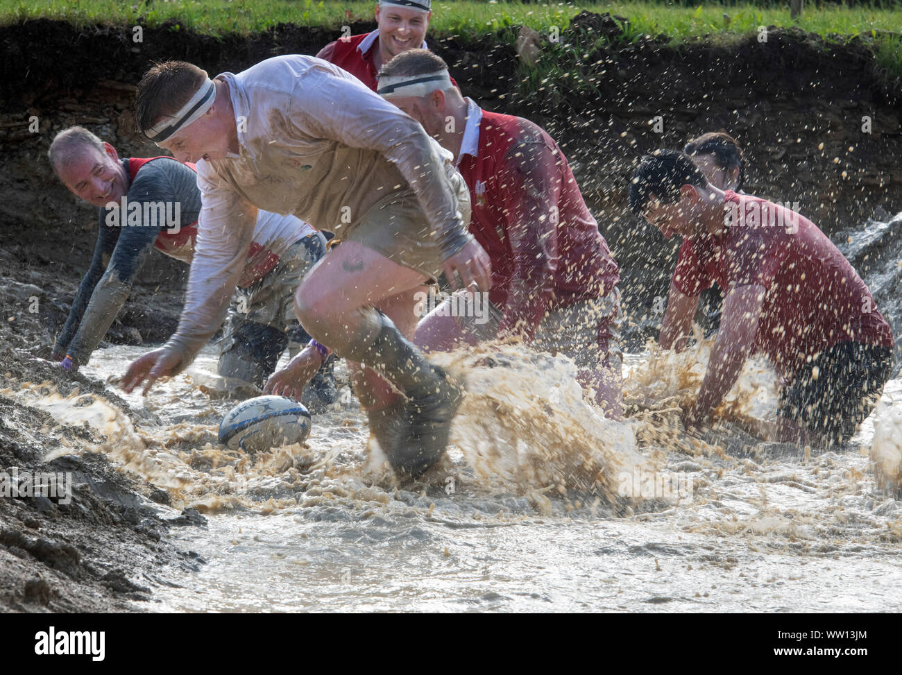Wettbewerber gekleidet, wie England und Wales Rugby Spieler auf der 'Mud Mile' an der haltbaren Mudder Ausdauer Event im Badminton Park, Gloucestershire, Großbritannien Stockfoto