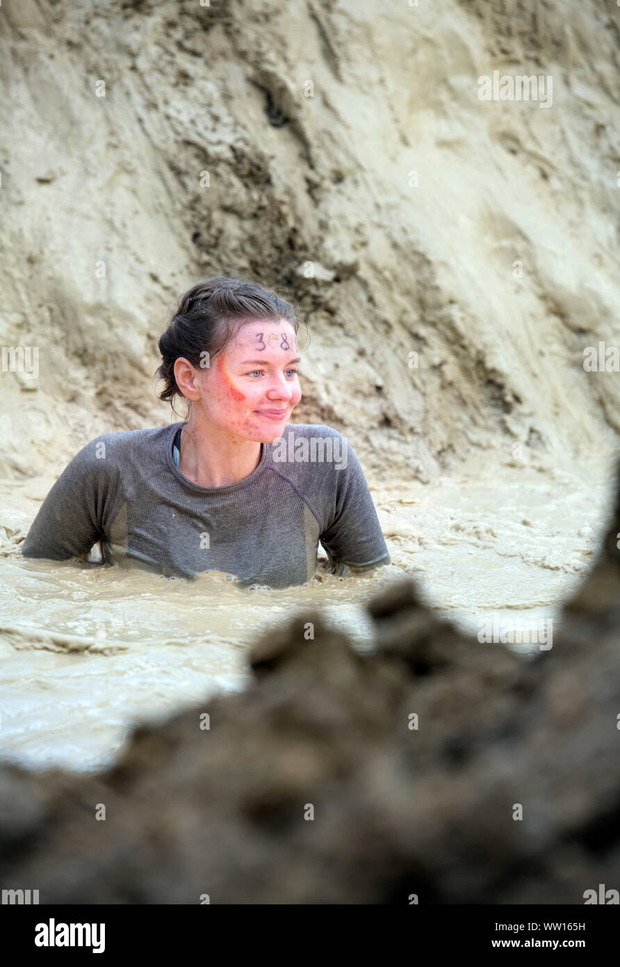 Ein Kandidat auf der 'Mud Mile' an der haltbaren Mudder Ausdauer Event im Badminton Park, Gloucestershire, Großbritannien Stockfoto