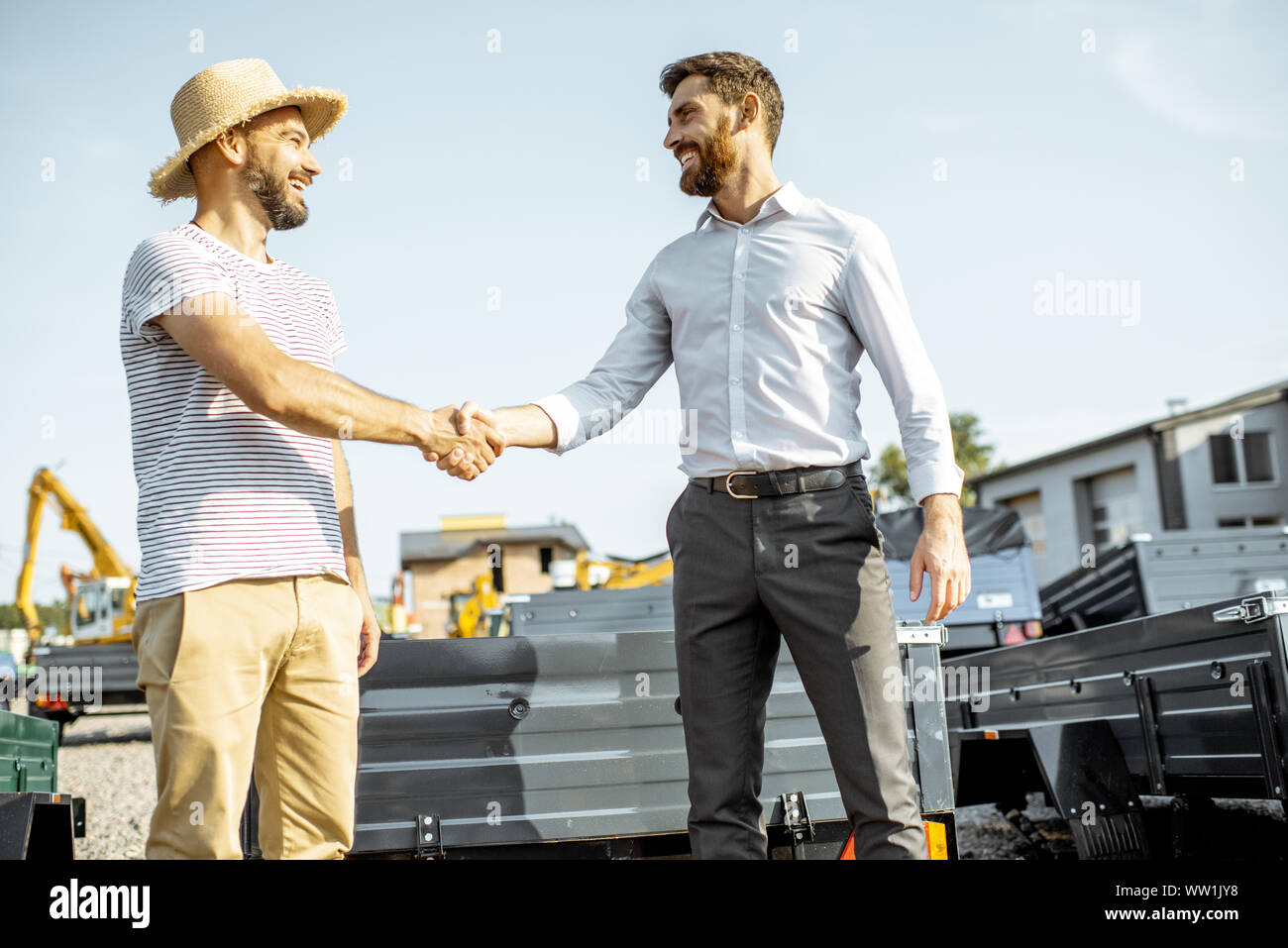 Agronom zitternden Hand mit Verkäufer, den Kauf eines neuen Farm LKW-Anhänger auf dem Boden der landwirtschaftlichen Shop Stockfoto