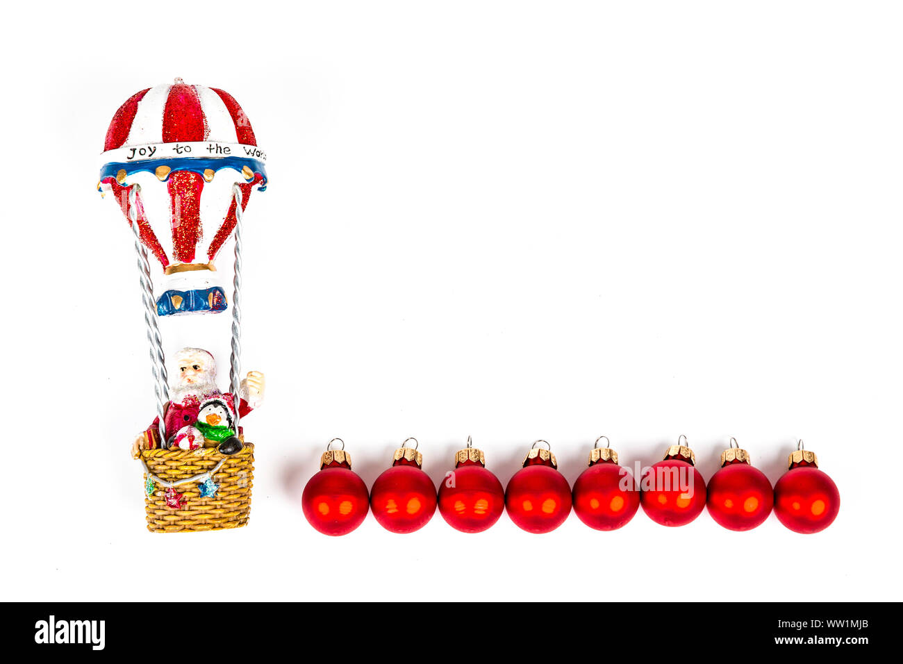 Santa Claus in Flug im Heißluftballon mit roten Kugeln Dekoration auf weißem Hintergrund. Ort schreibt Stockfoto