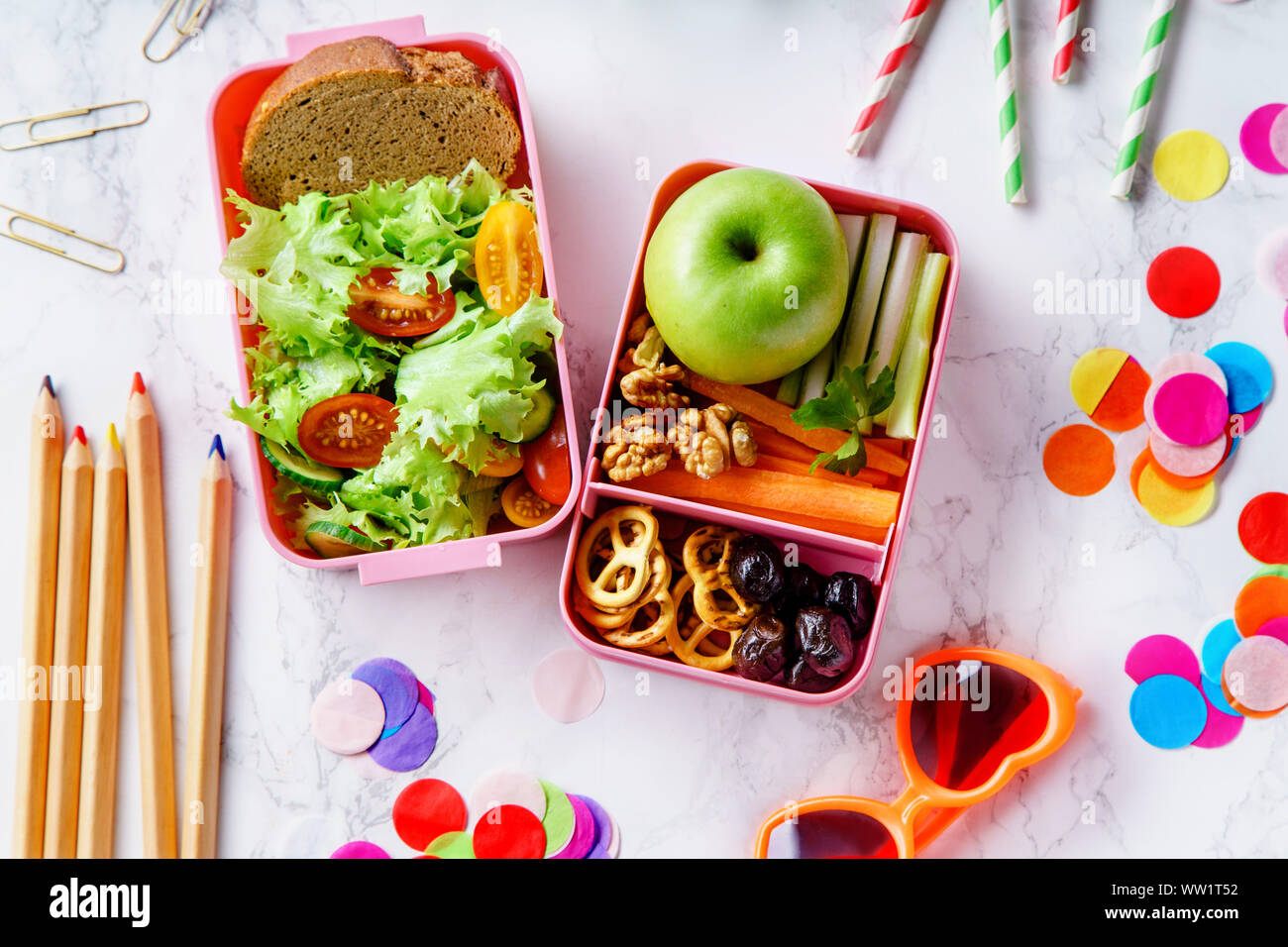 Lunch Box mit Salat und gesundes Essen für die Schule. Ansicht von oben Bild mit Buntstifte und Gläser für Kinder Stockfoto