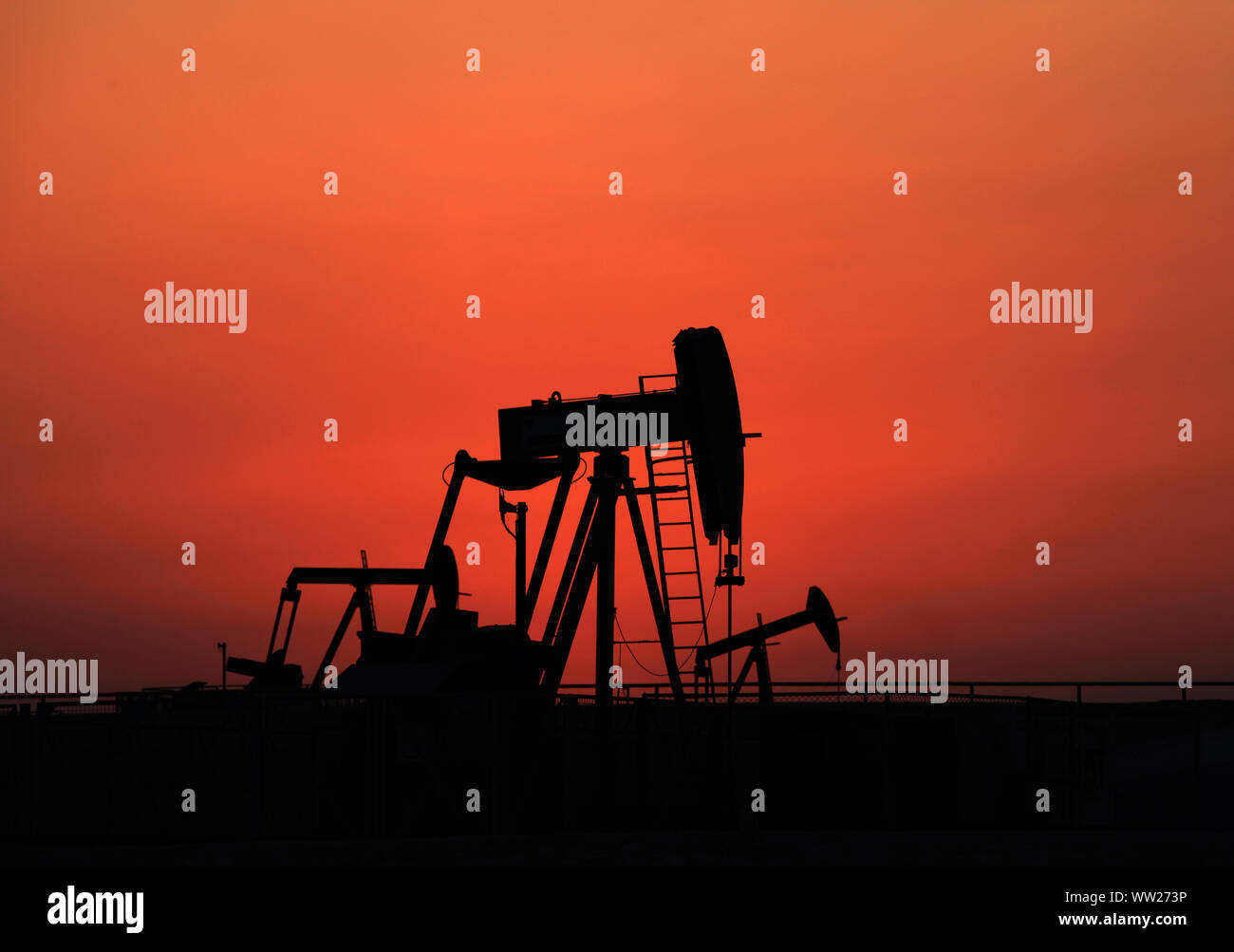 Öl pumpen Arbeiten bei Sonnenuntergang in der Wüste Ölfelder in Sakhir, Bahrain. Stockfoto
