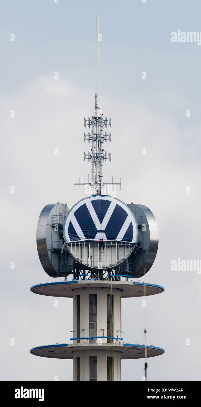 Hannover, Deutschland. 12 Sep, 2019. Arbeitnehmer Abrollen der neue Volkswagen Logo auf dem vwn Turm von Volkswagen Nutzfahrzeuge. Auf der im Volksmund als "Telemoritz" die drei riesigen VW-Logos sind derzeit ausgetauscht werden. Volkswagen hat sein Logo mehr einfach entworfen und ist nun Austausch weltweit. Credit: Julian Stratenschulte/dpa/Alamy leben Nachrichten Stockfoto