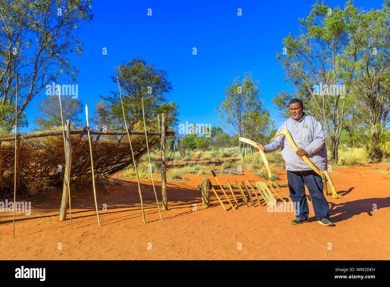 Der Kings Creek Station, Northern Territory, Australien - 21.August 2019: Australische Aborigines Mann zeigt eine hölzerne Boomerang und typische Jagdwaffen verwendet Stockfoto