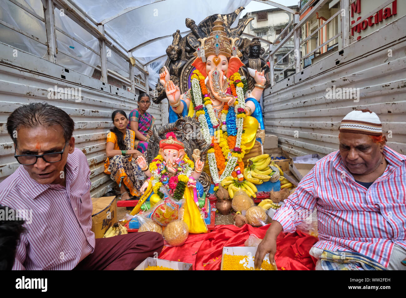 Während der Ganesh Festival Prozession in Mumbai, Indien, Anbeter der Elefantengott Ganesh (Ganpati) Fahrt mit einem Fahrzeug mit Ganesh Statuen Stockfoto