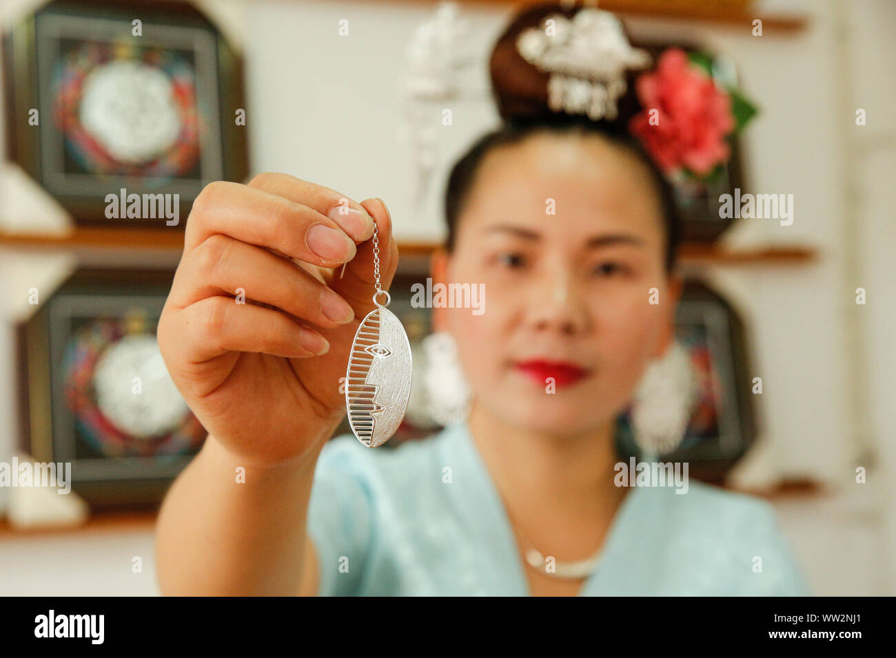 (190912)-BEIJING, Sept. 12, 2019 (Xinhua) - ein Handwerker der Miao ethnische Gruppe zeigt einen Silbernen Ohrring in Taijiang County, im Südwesten Chinas Provinz Guizhou, 22.08.2019. 'Mom Handworks' ist eine öffentliche Wohlfahrt Projekt von China Women Development Foundation (CWDF) im September 2016 eingeleitet. Etwa 46 'Mom Handworks Genossenschaften" wurden in 13 Provinzen bundesweit etabliert. Das Projekt hilft, Arbeitsplätze für Armut betroffene Mütter und sie mit einigen handwerklichen Fähigkeiten bieten Kunsthandwerk mit lokalen ethnischen Aromen zu machen, sowie die Probleme der einsame ältere Menschen lösen und Le Stockfoto