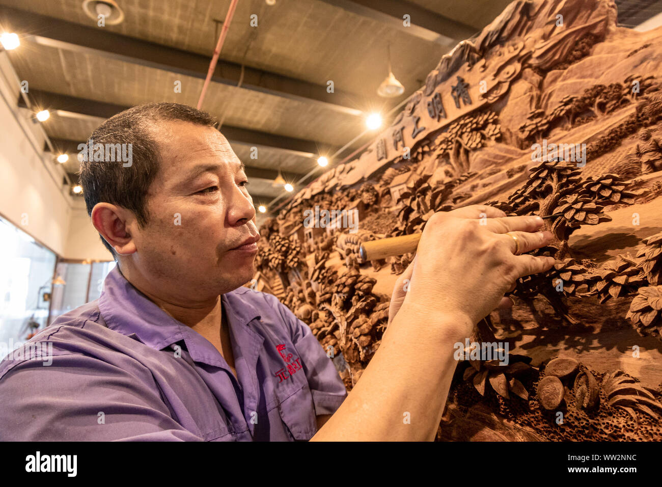 Eine Chinesische Handwerker schnitzt die Szenen in den alten chinesischen Malerei gezeigt', entlang des Flusses während der QINGMING Festival' auf einer Amtsleitung an Yuanhong Muse Stockfoto
