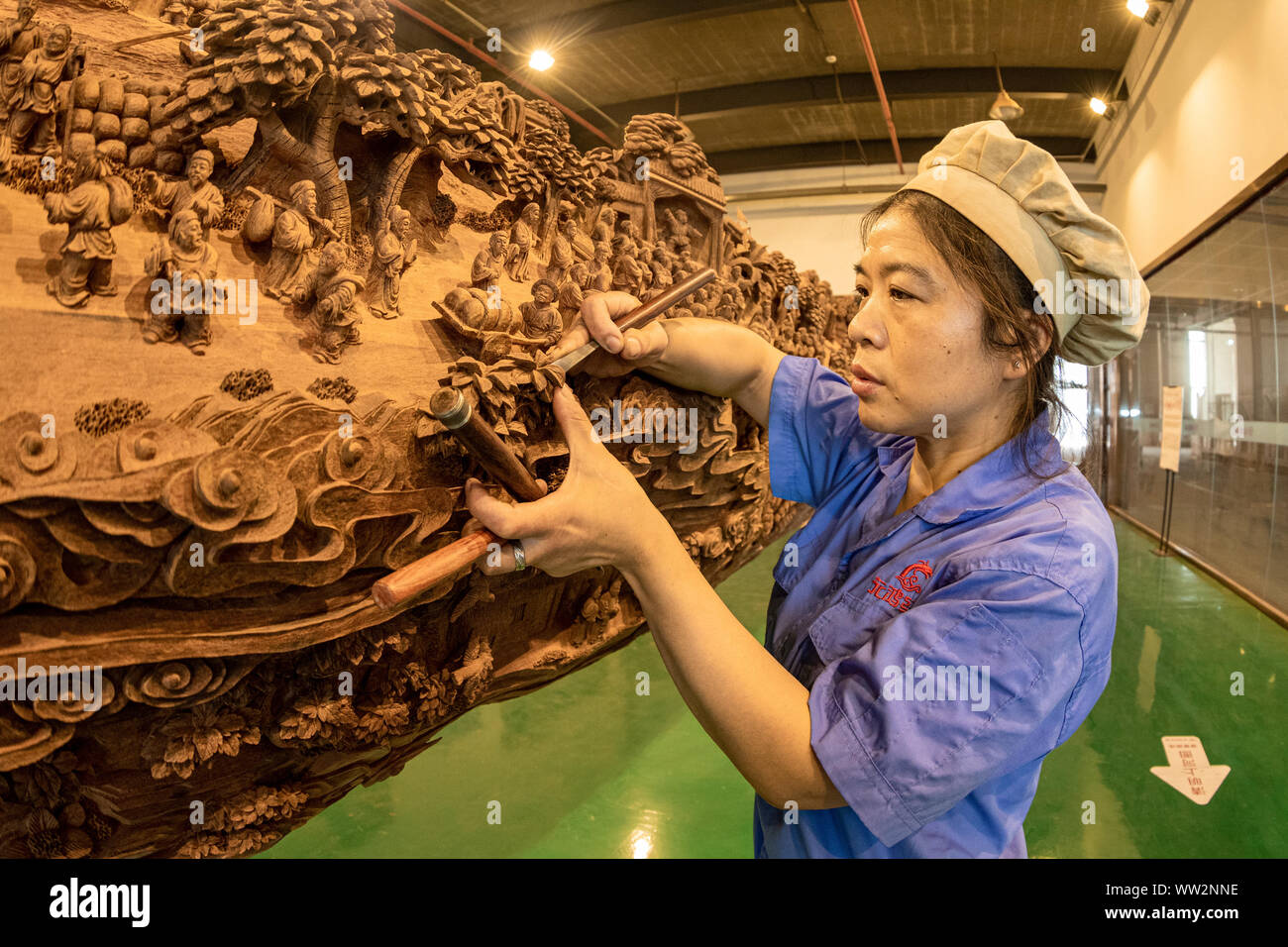 Eine chinesische Handwerkerin schnitzt die Szenen in den alten chinesischen Malerei gezeigt', entlang des Flusses während der QINGMING Festival' auf einer Amtsleitung an Yuanhong Mu Stockfoto