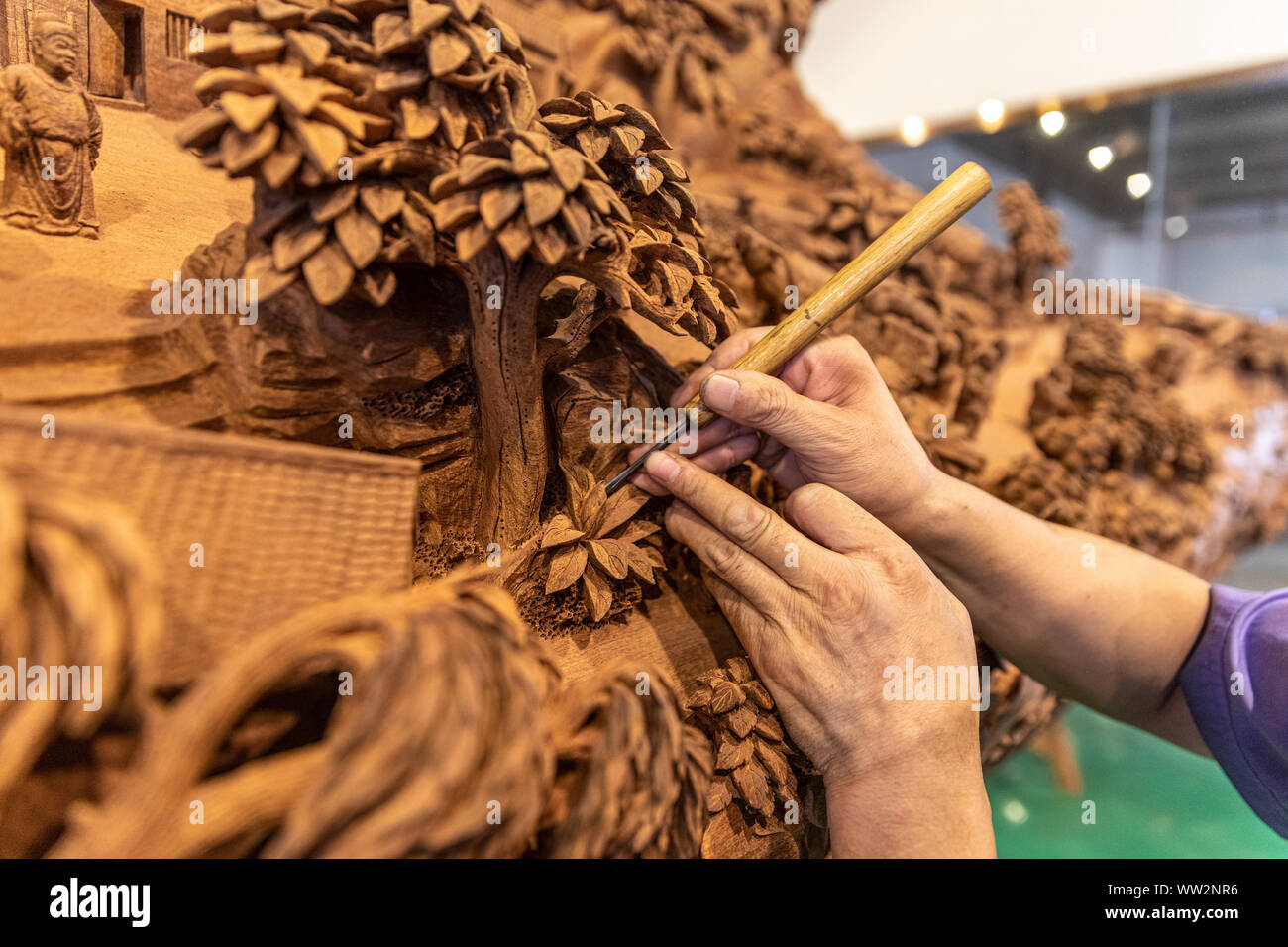 Eine Chinesische Handwerker schnitzt die Szenen in den alten chinesischen Malerei gezeigt', entlang des Flusses während der QINGMING Festival' auf einer Amtsleitung an Yuanhong Muse Stockfoto