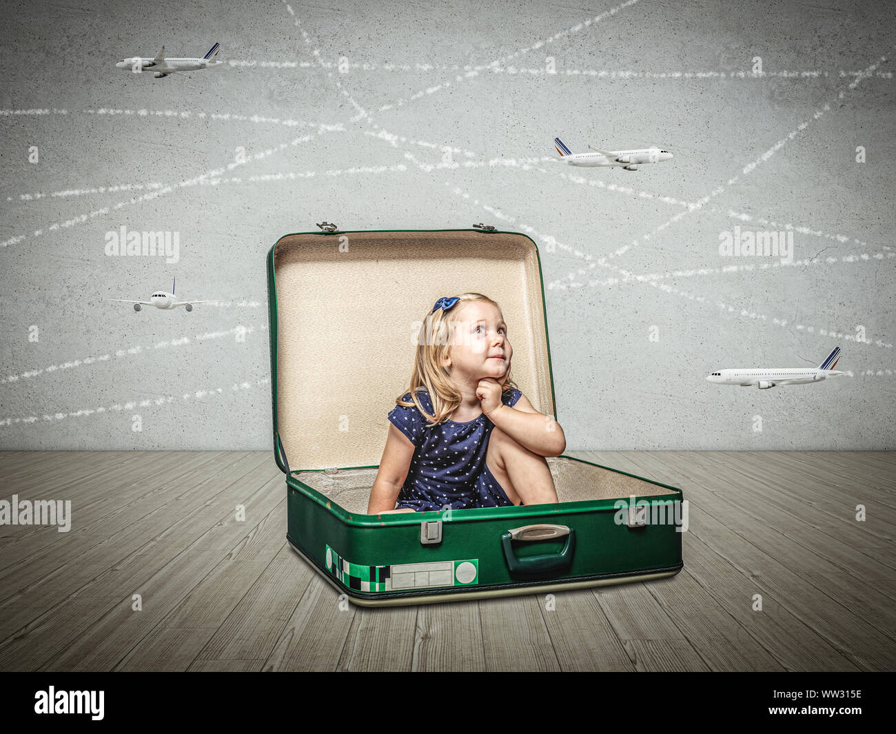 Kleines Mädchen in einem alten Koffer stellt sich Abenteuer und Träume von Reisen zu sitzen. Flugzeuge Modelle fliegen durch den Raum. Stockfoto