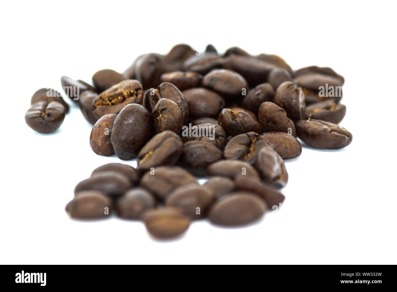 Nahaufnahme von gerösteten Kaffeebohnen schwarz auf weißem Hintergrund Stockfoto