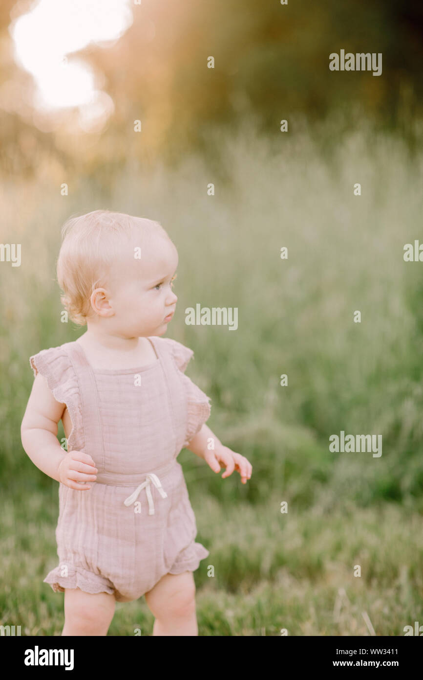 Baby Mädchen in aus der Sonnenuntergang in einem Feld Stockfoto
