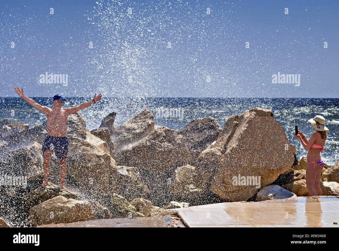 Junge Leute haben Spaß unter dem Spritzwasser der Wellen im Meer, Schwarzes Meer Bulgarien; Stockfoto