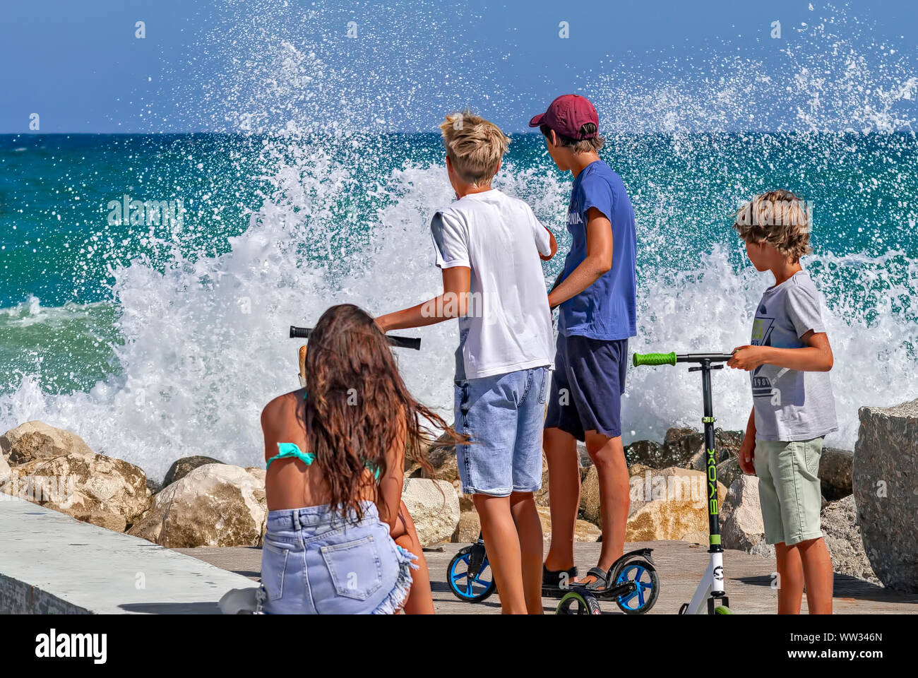 Kinder spielen auf der Pier unter dem Spritzwasser der Wellen im Meer, Schwarzes Meer Bulgarien; Stockfoto