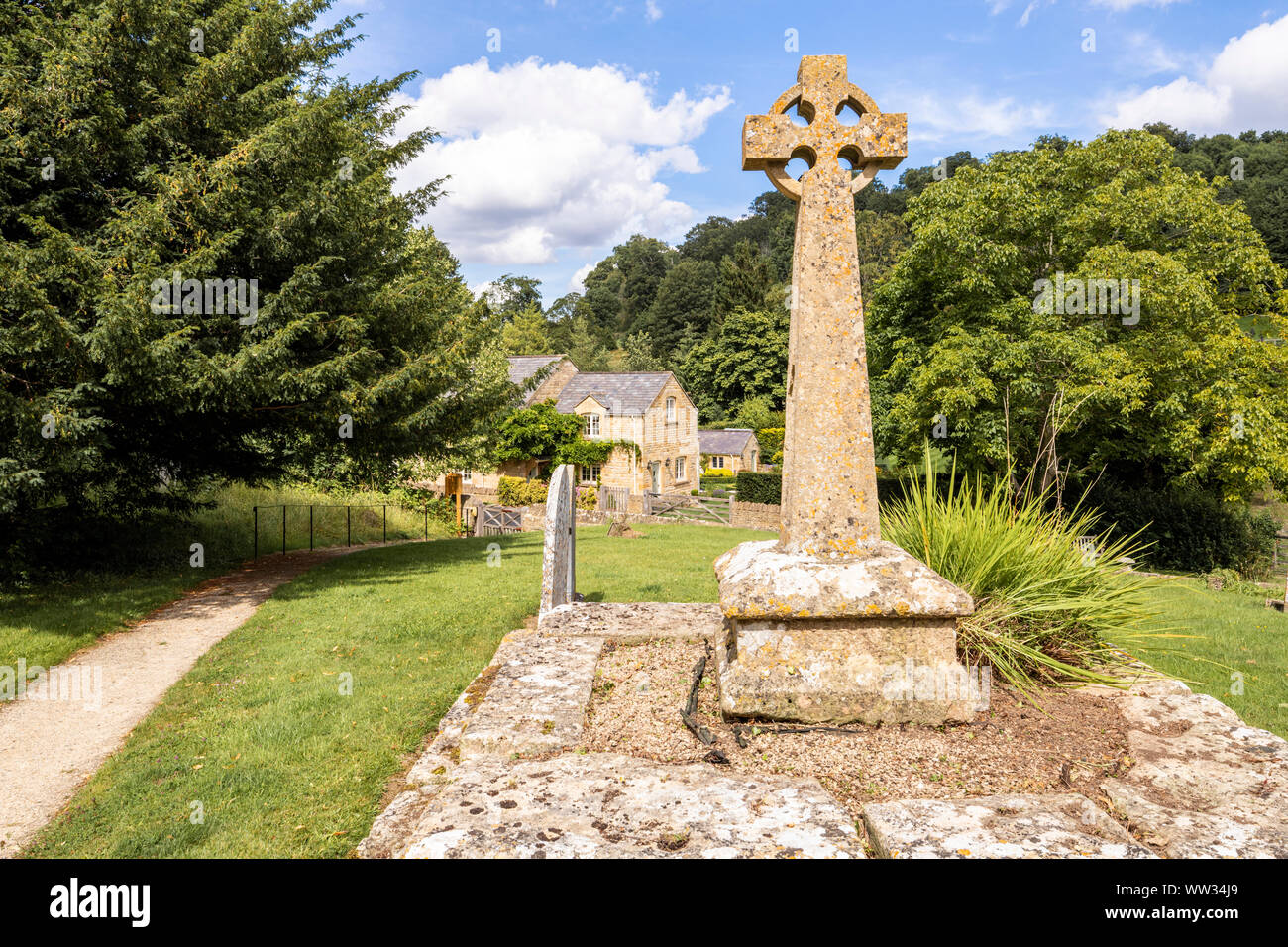 Viktorianische keltischen Friedhof Kreuz auf einem mittelalterlichen Basis im Kirchhof der St. Michaels Kirche in der Cotswold Dorf Buckland, Gloucestershire, Großbritannien Stockfoto