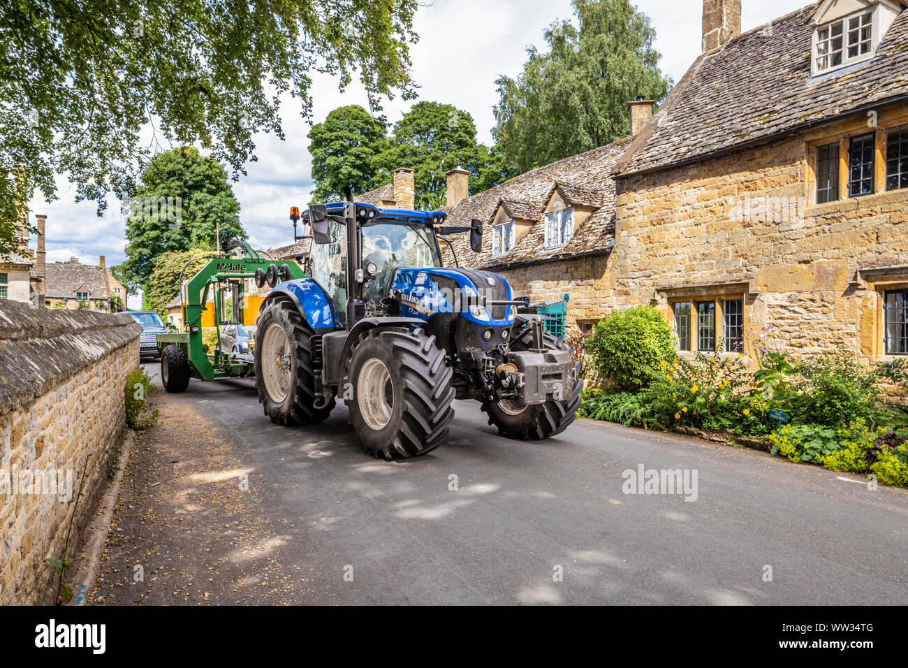 Schwere landwirtschaftliche Maschinen verhandeln über eine schmale Gasse in der Cotswold Dorf Snowshill, Gloucestershire, Großbritannien Stockfoto