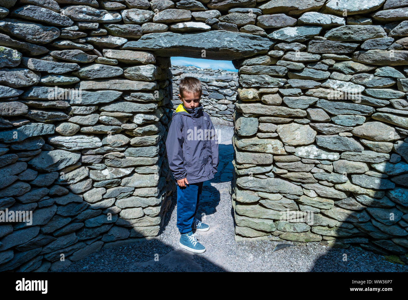 Boy steht an der Schwelle einer clochan an caher Conor in Halbinsel Dingle Irland Stockfoto