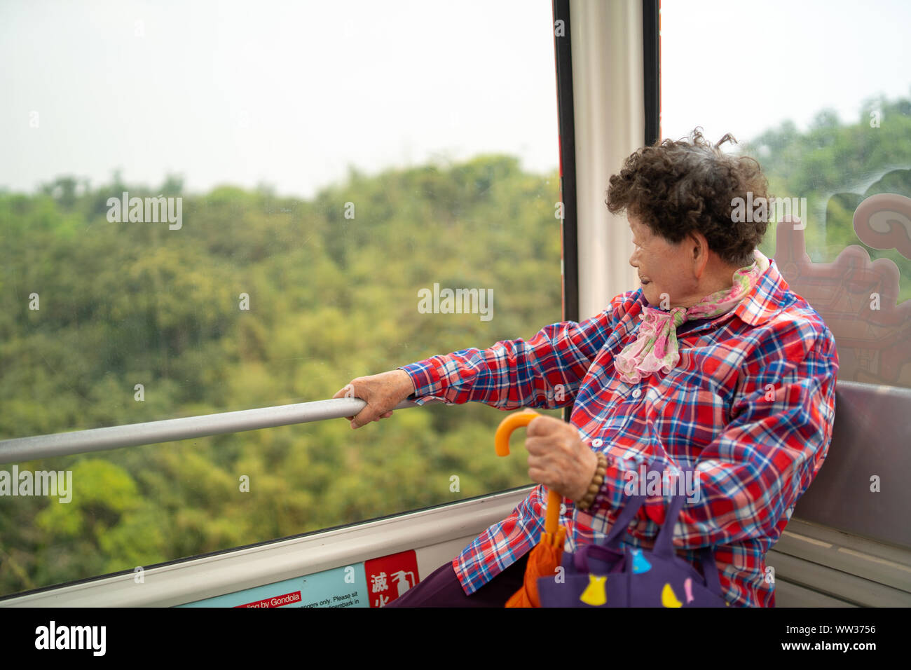 Taipei, Taiwan - 09. April 2019: Taiwanische grandma Blick aus Fenster und genießen Sie die Fahrt mit der Gondel Maokong Stockfoto