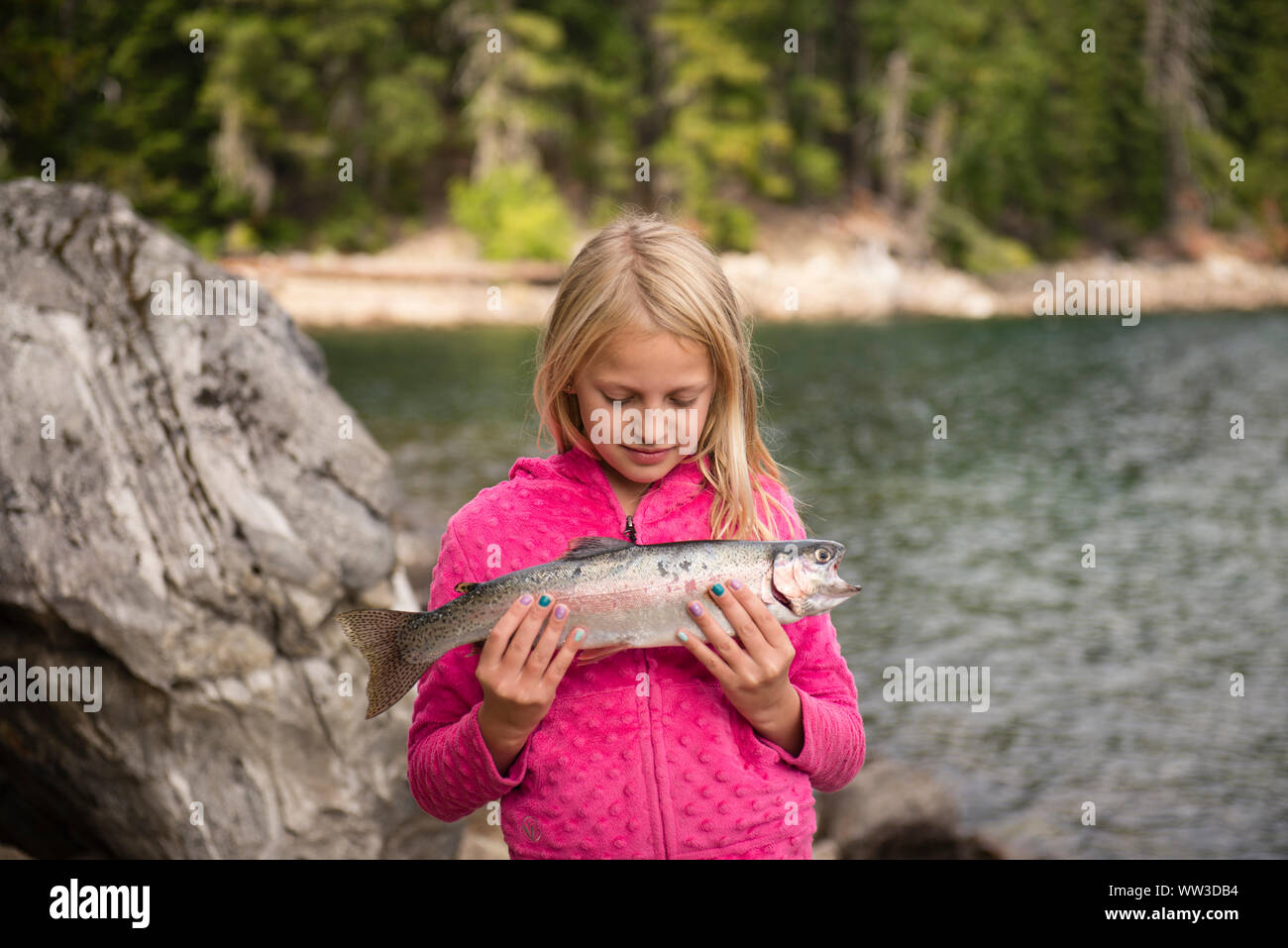 Portrait von 8-9 Jahre alten Mädchen, dass ein Fisch an einem See Stockfoto
