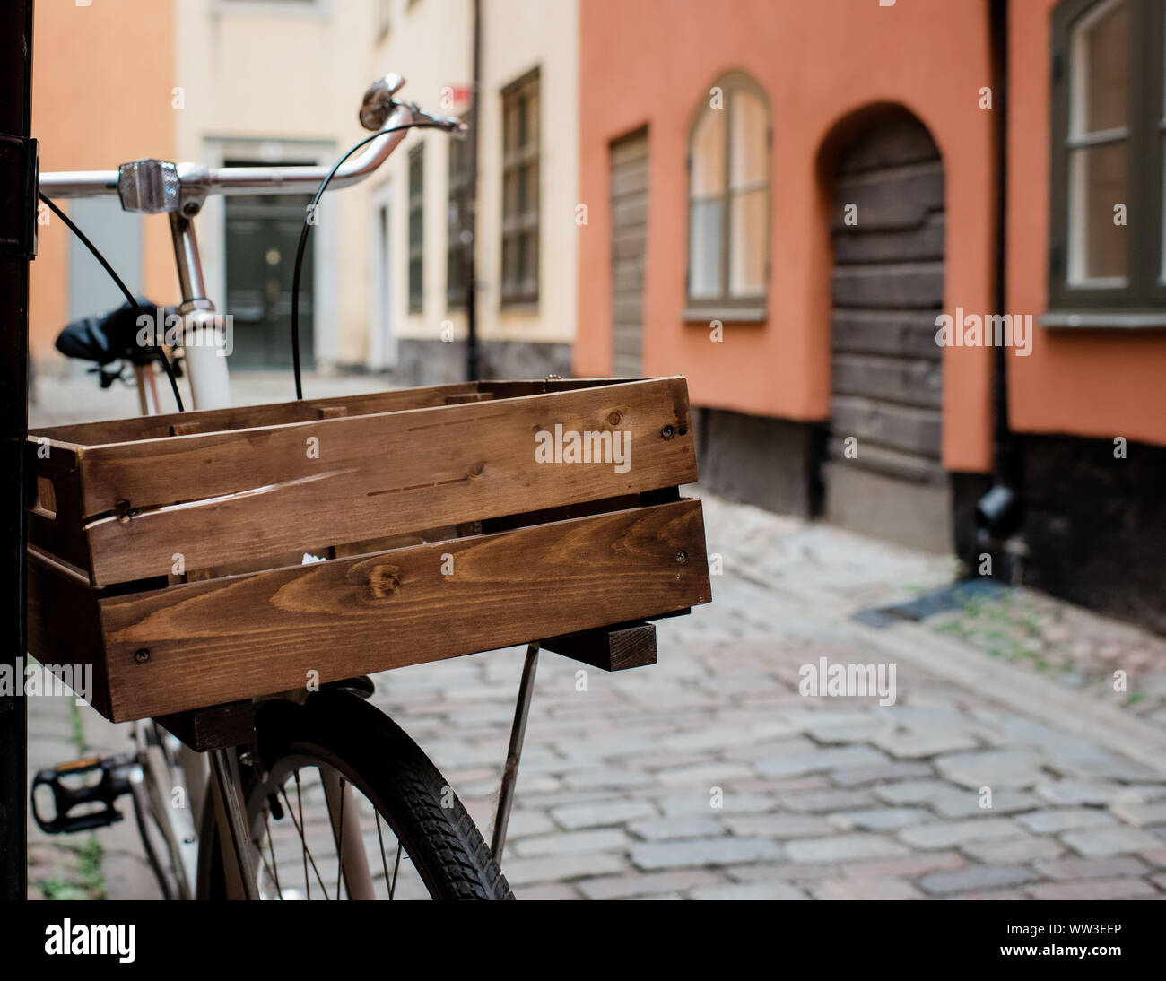 Vintage Holz- Korb auf einem Fahrrad auf einer gepflasterten Straße in Europa Stockfoto