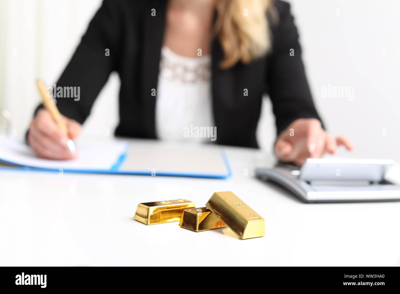 Frau mit Gold Bar bullion und Rechner Stockfoto