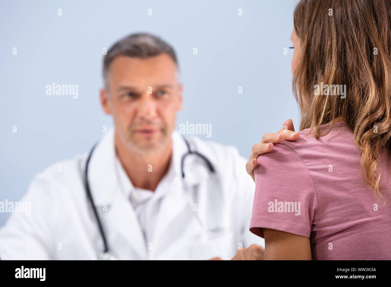 Reifen Arzt suchen Bei weiblichen Patienten zeigen Ihr Paining Schulter in Klinik Stockfoto Reifen Arzt suchen Bei weiblichen Patienten zeigen Ihr Paining Schulter in Klinik Stockfoto